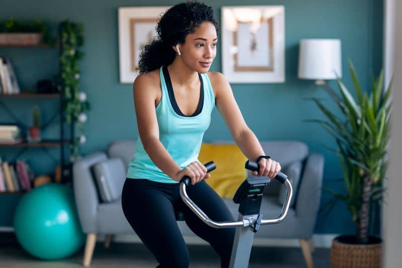 Woman exercising on fitness bike. Woman exercising on fitness bike.