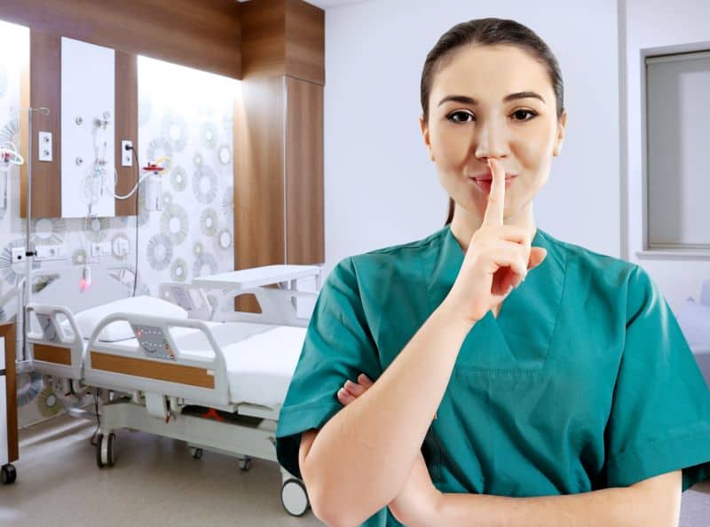 Young female nurse making a silence hand gesture in hospital Young female nurse making a silence hand gesture in hospital
