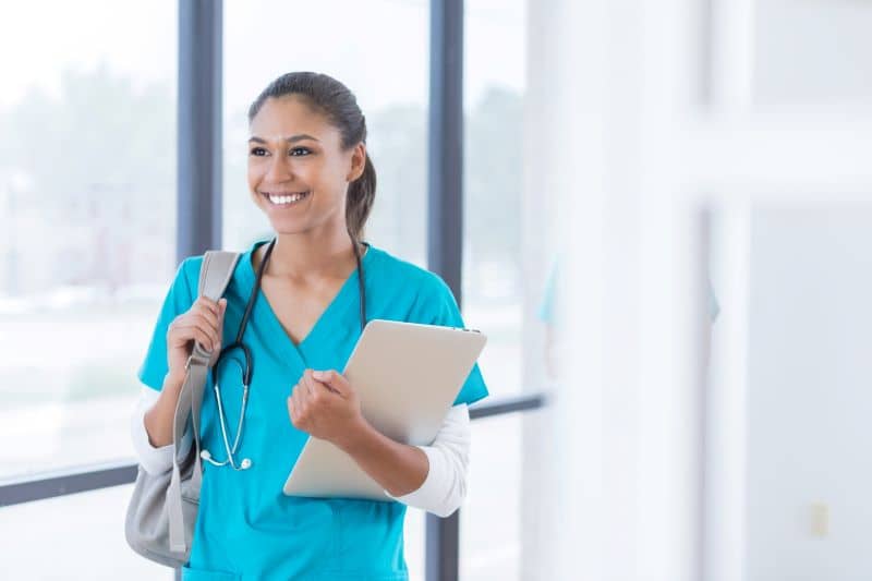 Confident young female medical student walks in the hallway on her way to class. Confident young female medical student walks in the hallway on her way to class.