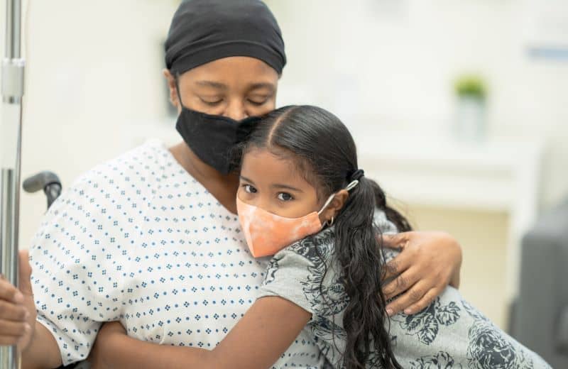 A female patient receives hug from her younger daughter. A female patient receives hug from her younger daughter.