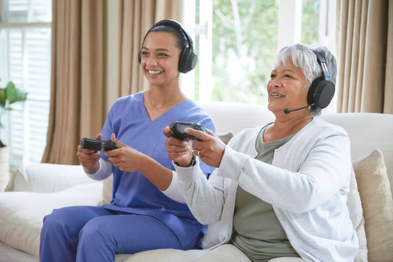 Senior woman with her elder care nurse playing Senior woman with her elder care nurse playing