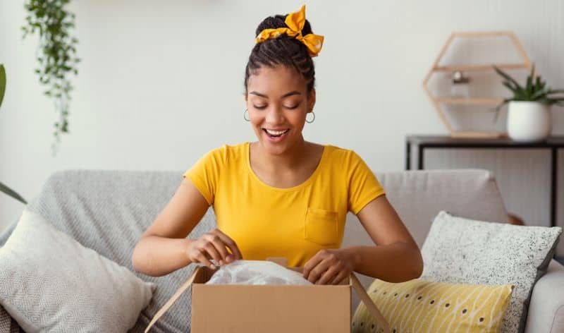 Happy woman unpacking box after online shopping. Happy woman unpacking box after online shopping.
