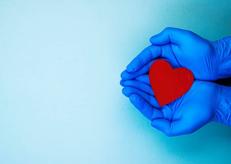 red heart in hands in blue medical gloves red heart in hands in blue medical gloves