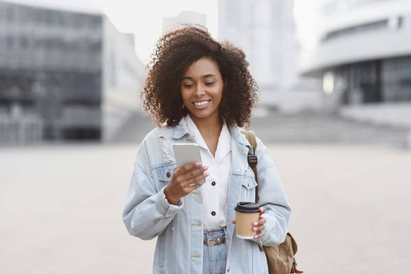 Young woman using smart phone on a city street Young woman using smart phone on a city street