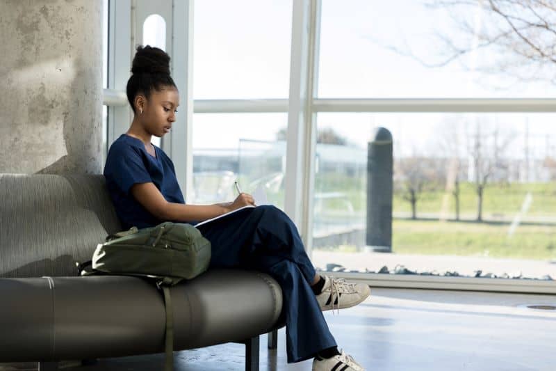 A young adult female student studies her notes before class. A young adult female student studies her notes before class.