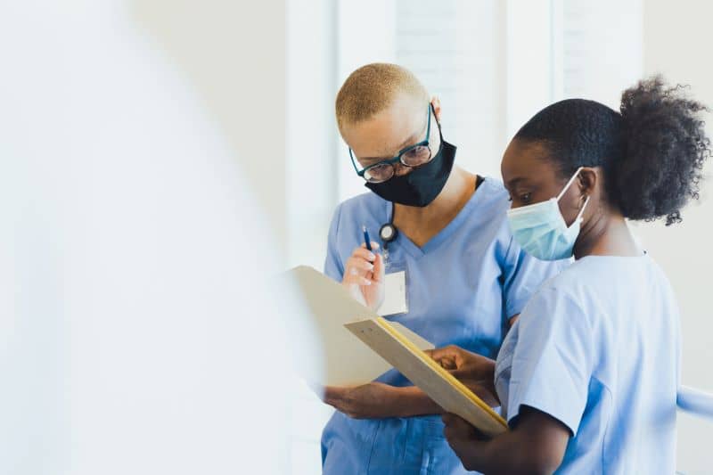 Two female doctors review a patient's test results. Two female doctors review a patient's test results.