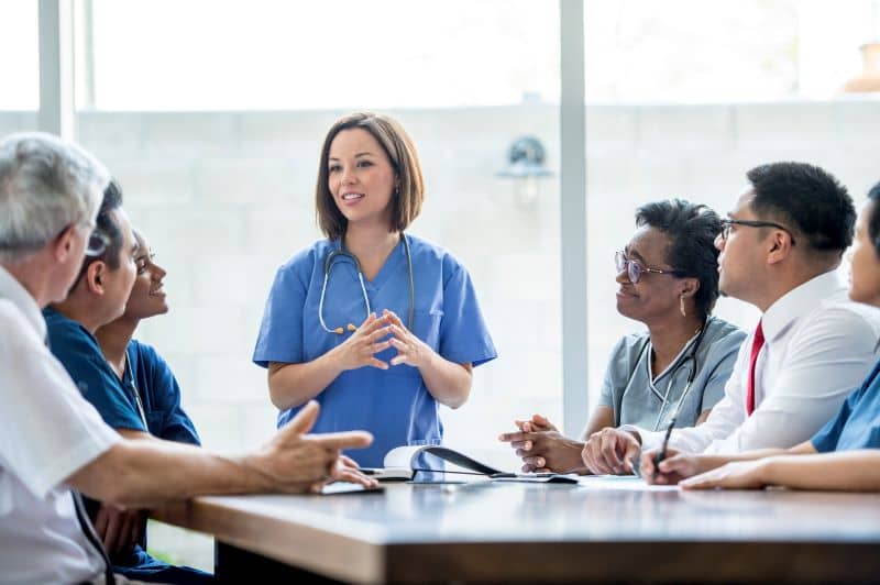 A group of medical staff are indoors in a hospital. A group of medical staff are indoors in a hospital.