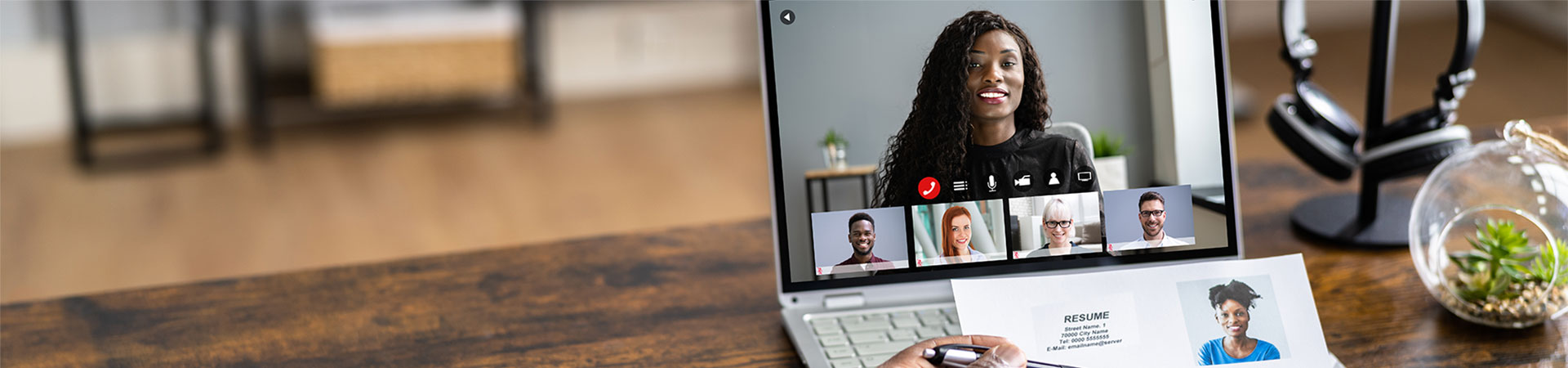 Young African American female conducting an online interview with several other healthcare professionals in attendance.